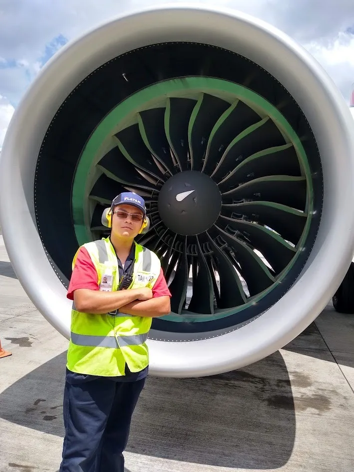 Gabriel em frente à turbina de um avião no aeroporto de Porto Alegre